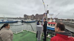 Mensen op een schip met boten en haven in Lelystad, betrokken bij Zeekadetkorps.